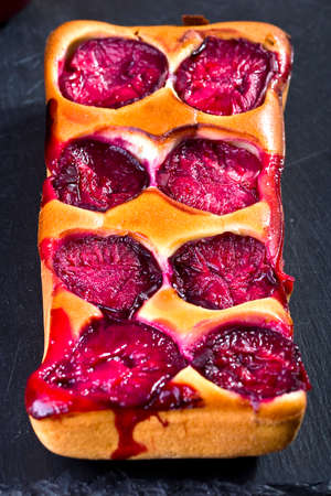 dough with whole juicy plumsの写真素材