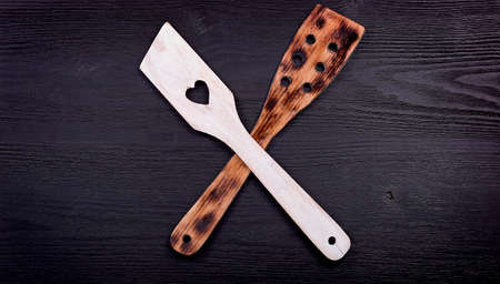 wooden spoon with a heart on a black wood background