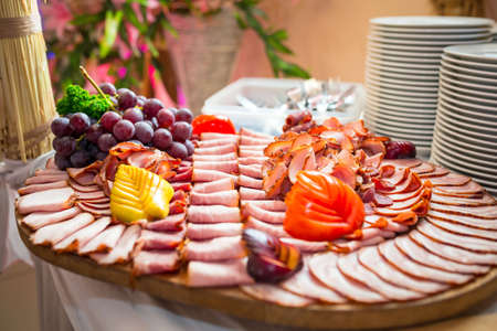 Choice of smoked ham and sausages on the tableの写真素材
