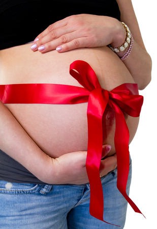 Pregnant woman with ribbon around her tummyの写真素材