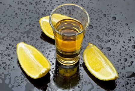 Whiskey shot with sliced lemonの写真素材