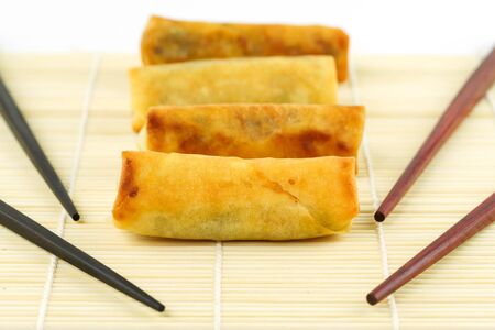 Chinese spring rolls with chopsticks on the bamboo matの写真素材