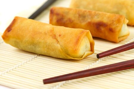 Chinese spring rolls with chopsticks on the bamboo matの写真素材