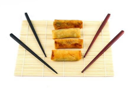 Chinese spring rolls with chopsticks on the bamboo matの写真素材