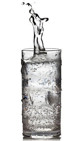 Cube of ice dropped into the glass of sparkling waterの写真素材