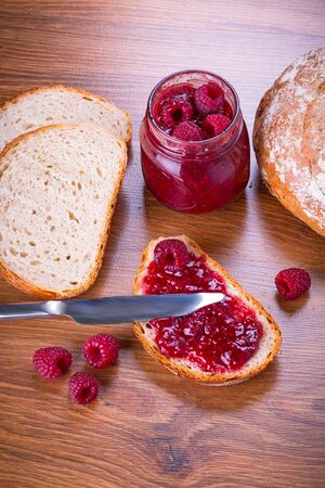 Rapsberry jam on a slice of breadの写真素材