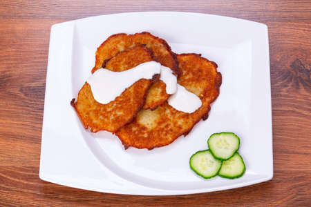 Potato pancakes with sour cream on the plateの写真素材