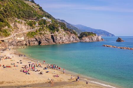 People relaxing on the beach of Monterosso in Italyの写真素材