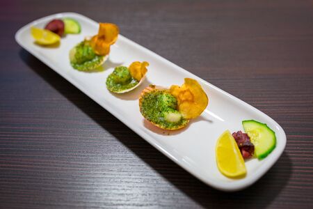 Scallops in shells with garlic butter on the plateの写真素材