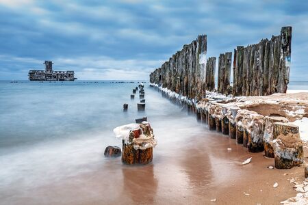 Frozen wooden breakwaters line to the World War II torpedo platform at Baltic Sea, Babie Doly, Polandの写真素材