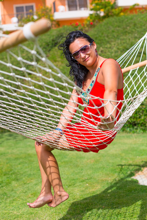 Beautiful woman relaxing on the hammockの写真素材