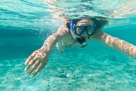 Woman snorkeling in the tropical waterの写真素材