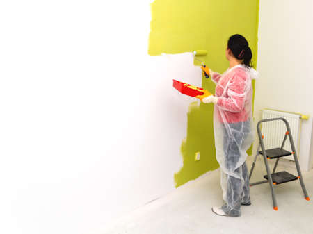 Woman painting interior wall of houseの写真素材