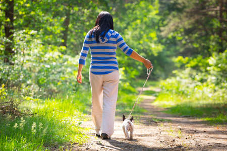 Beautiful woman walking her french bulldog puppyの写真素材