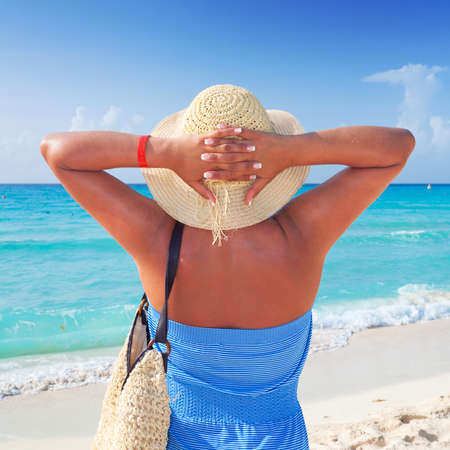 Woman in hat feeling happy on the beachの写真素材