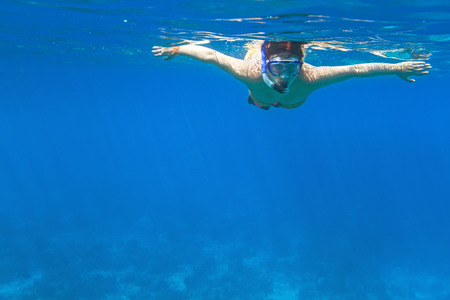 Woman snorkeling in the tropical waterの写真素材