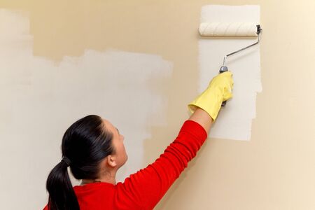Woman painting interior wall of houseの写真素材