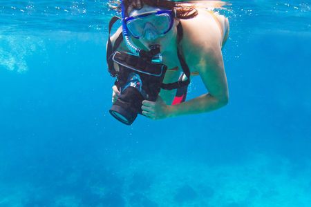 Woman snorkeling in the tropical water with an underwater cameraの写真素材