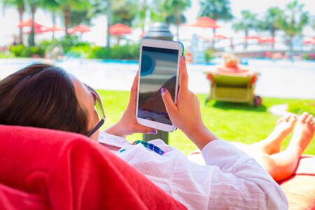 Woman reading on electronic book on summer holidaysの写真素材