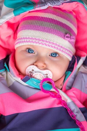 Portrait of baby girl in winter jacket and hatの写真素材