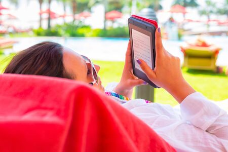 Woman reading on electronic book on summer holidaysの写真素材