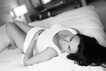 Beautiful pregnant woman lying in bedの写真素材
