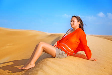 Beautiful woman with scarf in the desertの写真素材