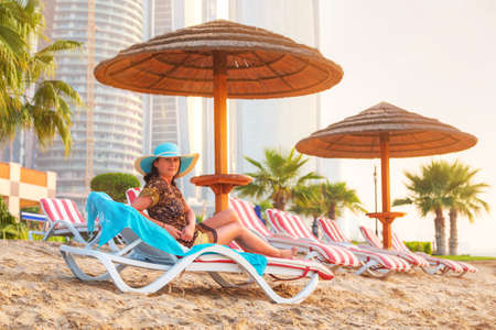 Woman posing on deckchair at sunrise in Abu Dhabiの写真素材