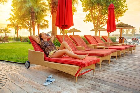 Woman relaxing on deckchair at sunriseの写真素材
