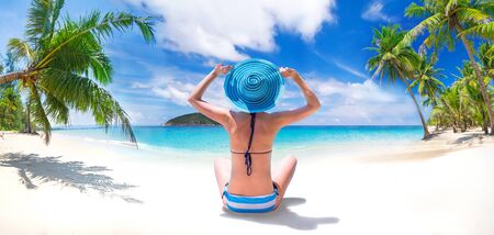 Woman enjoying the sun by the seashoreの写真素材