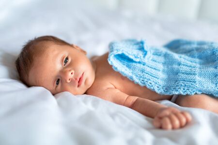 Newborn baby boy lying down in bedの写真素材