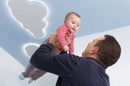 Man holding newborn baby up in the airの写真素材