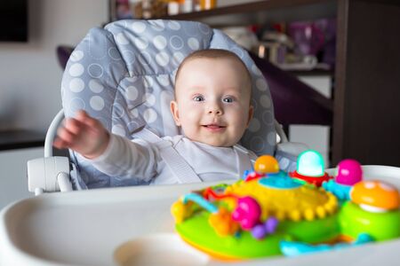 Baby boy sitting on the high chair for joyの写真素材