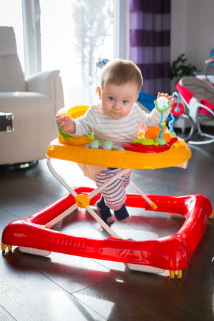 First steps in the baby walker by little baby boyの写真素材