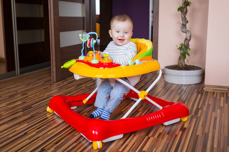 First steps of the boy in a baby walkerの写真素材