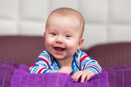 Smiling baby boy lie on his tummyの写真素材