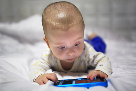 Baby boy watching movie on the mobile phoneの写真素材