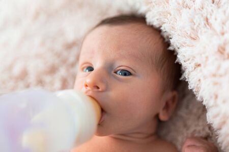 Feeding baby boy with milk from the bottleの写真素材