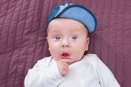 Baby boy in hat posing at the cameraの写真素材