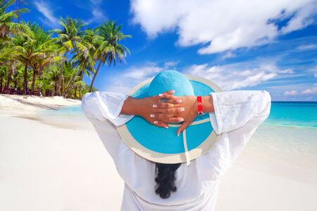 Woman in hat relaxing on the beachの写真素材