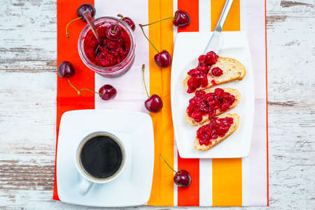Sandwiches with cherry jam and coffee for breakfastの写真素材