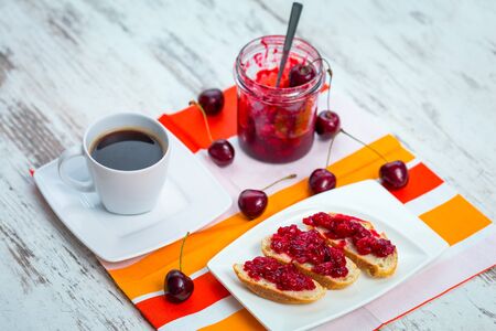 Sandwiches with cherry jam and coffee for breakfastの写真素材