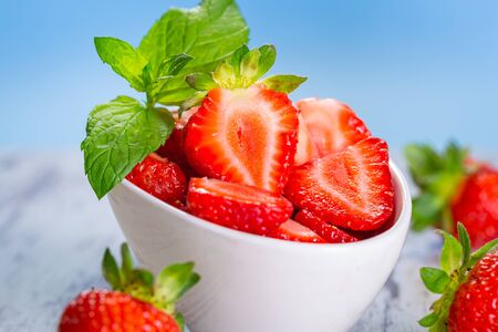 Strawberries in a bowl on wooden tableの写真素材