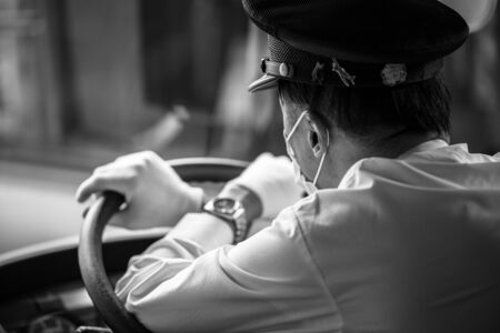 KYOTO, JAPAN - NOVEMBER 11, 2016: Kyoto city bus driver wearing mask at work, Japan. Buses are the main public transportation system in Kyoto.のeditorial素材