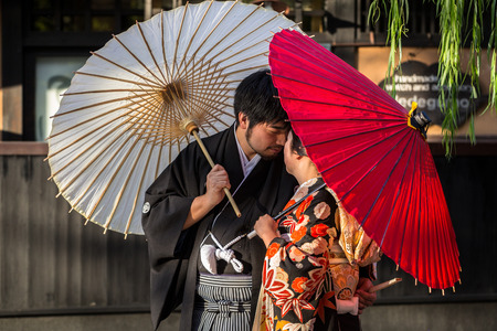 KYOTO, JAPAN - NOVEMBER 11, 2016: Japanese couple wearing traditional japanese kimonos walk on the street of Gion, Kyoto old town, Japan. Kimono is a Japanese traditional garment.のeditorial素材