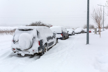 Snowy street with cars after winter snowfall in Polandの写真素材