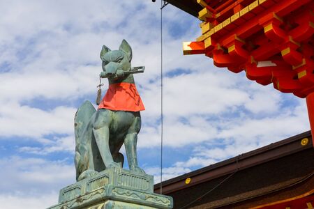 KYOTO, JAPAN - NOVEMBER 10, 2016 : Stone fox on guard at Fushimi Inari Shrine torii gate in Kyoto, Japan. Torii is a traditional Japanese gate commonly found in a shrine.のeditorial素材