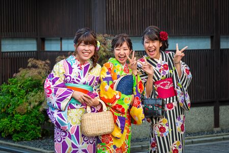 KYOTO, JAPAN - NOVEMBER 11, 2016: Young women wearing traditional japanese kimono walk on the street of Gion, Kyoto old town, Japan. Kimono is a Japanese traditional garment.のeditorial素材