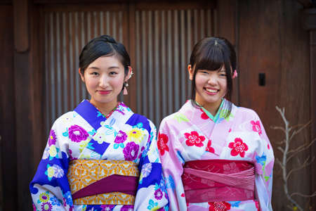 KYOTO, JAPAN - NOVEMBER 11, 2016: Young women wearing traditional japanese kimono walk on the street of Gion, Kyoto old town, Japan. Kimono is a Japanese traditional garment.のeditorial素材