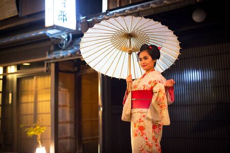 KYOTO, JAPAN - NOVEMBER 10, 2016: Young woman wearing traditional japanese kimono walk on the street of Gion, Kyoto old town, Japan. Kimono is a Japanese traditional garment.のeditorial素材